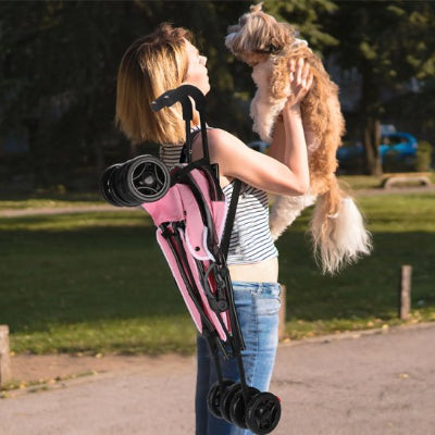 femme portant poussette pour chien rose epaule
